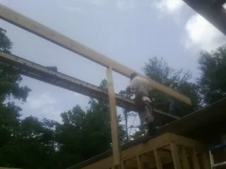 Carpenter setting a ridge beam over a new addition frame — Ice Dam Removal by Roofing Brothers in Cudahy