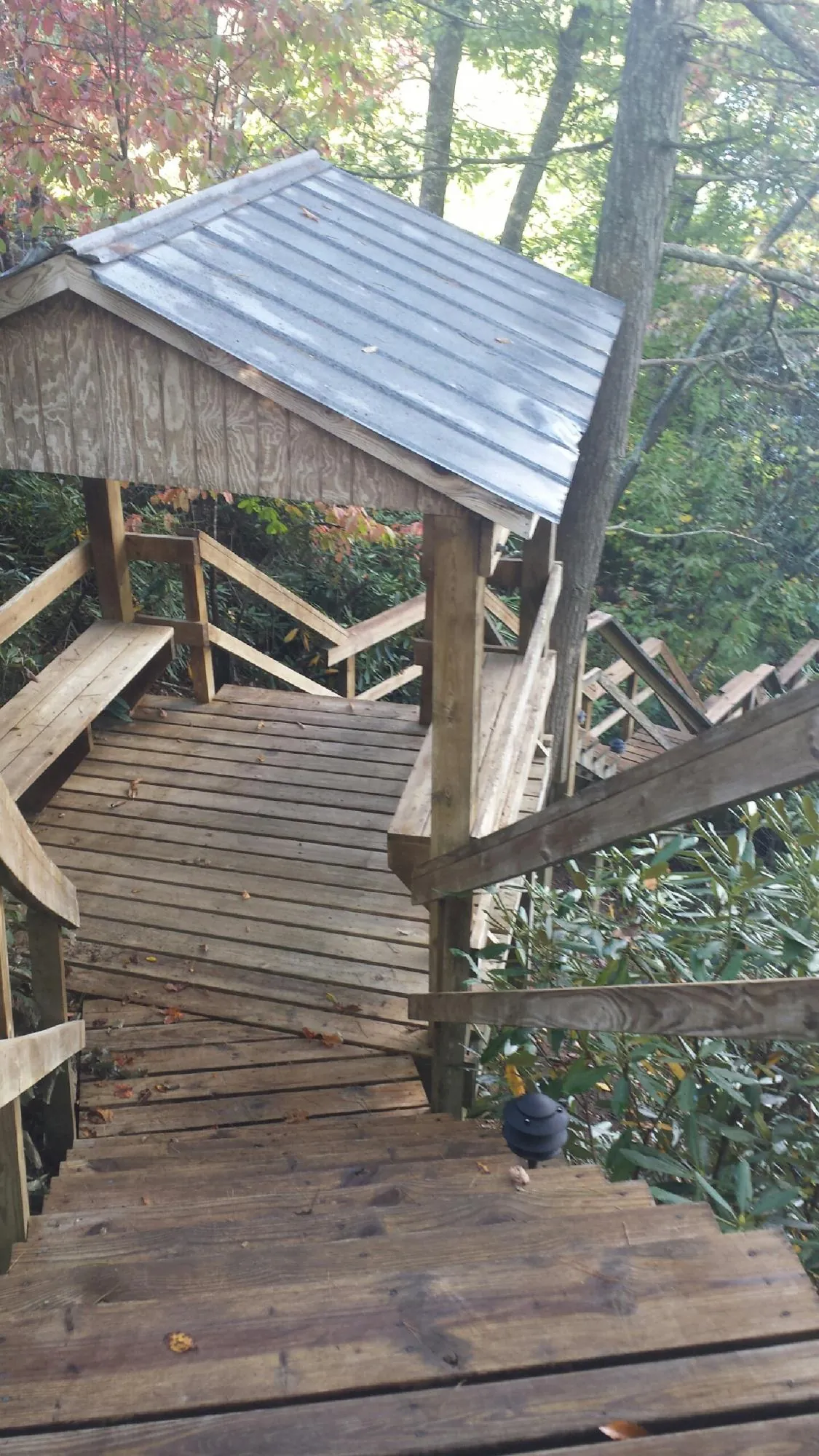 Metal roofed shelter over wooden steps on a wooded walkway — Skylight Repair & Installation work by our crew in Cudahy
