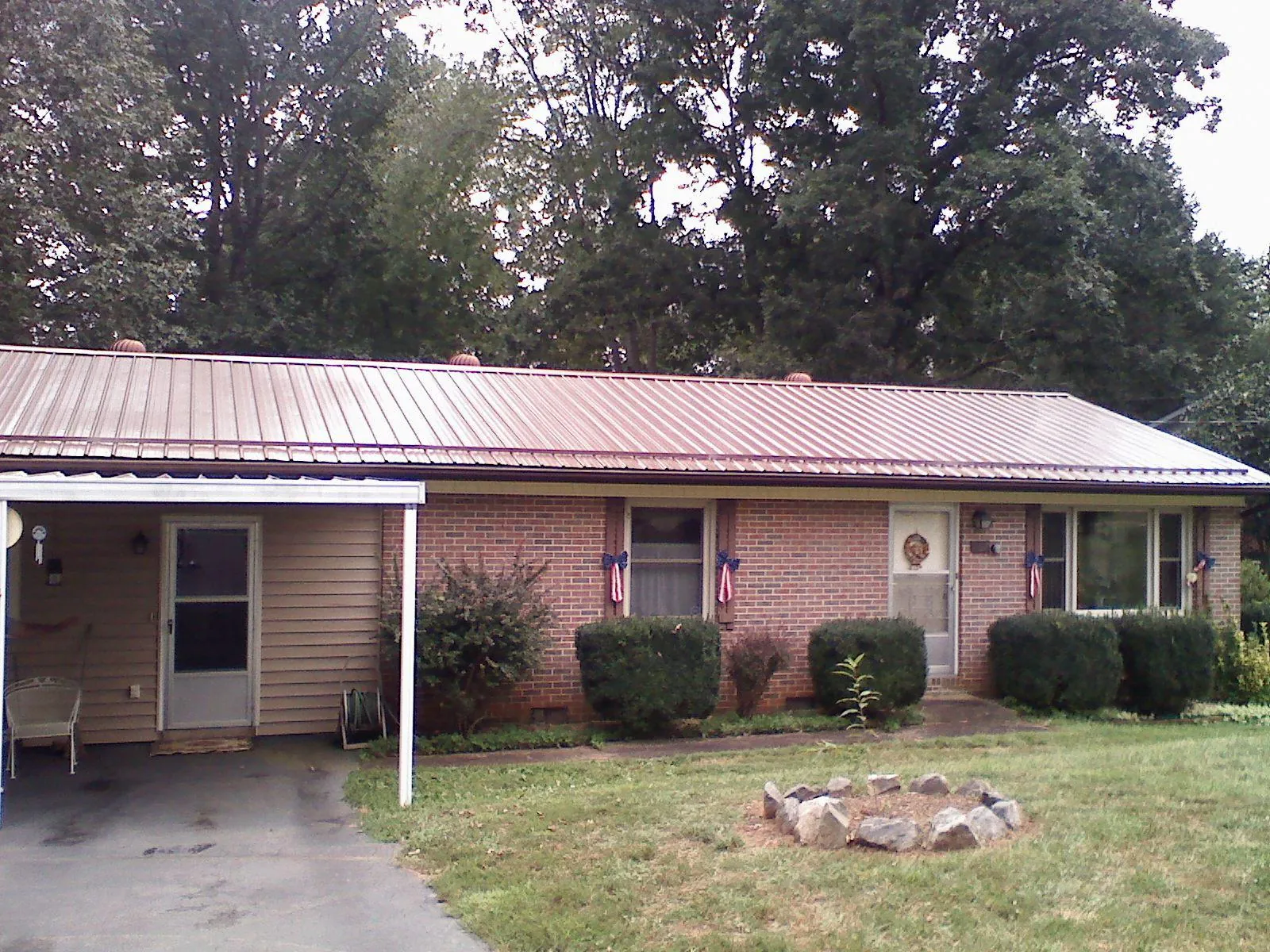 Bronze metal roof and carport on a brick ranch home — Roof Repair work by our crew in Cudahy