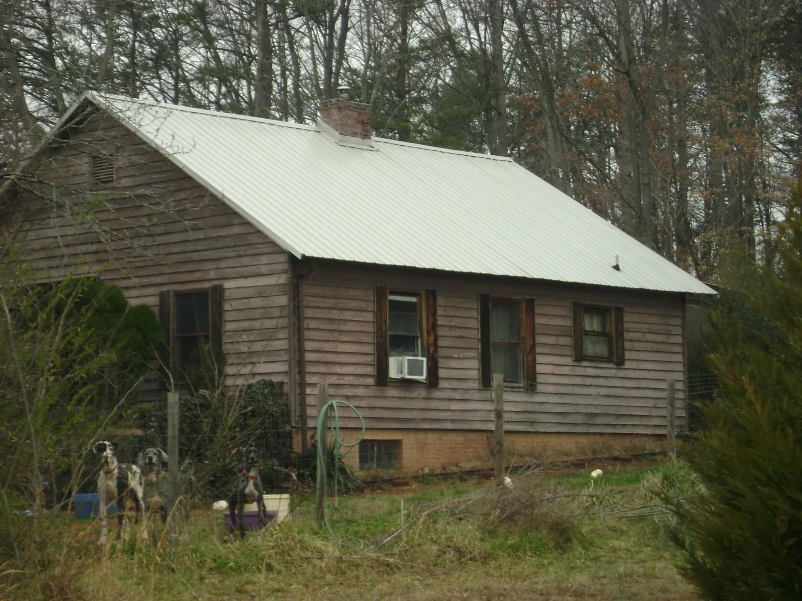 White metal roof on an old wood sided farmhouse, from a Metal Roof Installation job in Cudahy